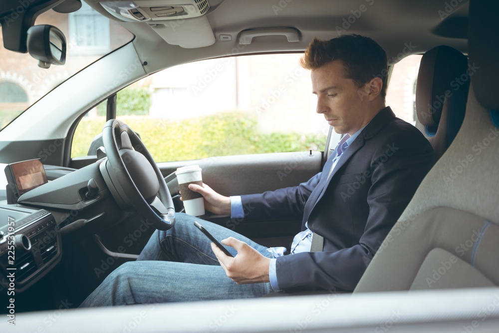 Businessman using mobile phone while driving car Businessman using mobile phone while driving car