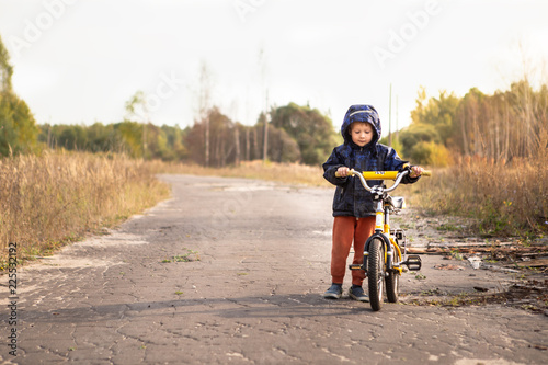 Boy learning to ride bike in autumn