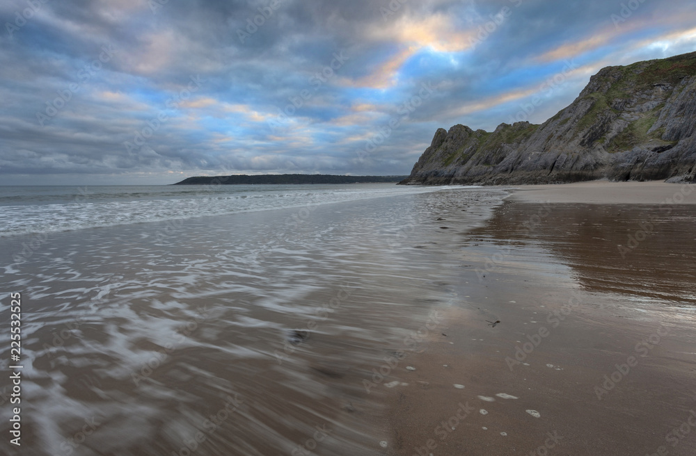 Gower evening and incoming tide at The Great Tor and Three Cliffs Bay, Swansea, Wales, UK
