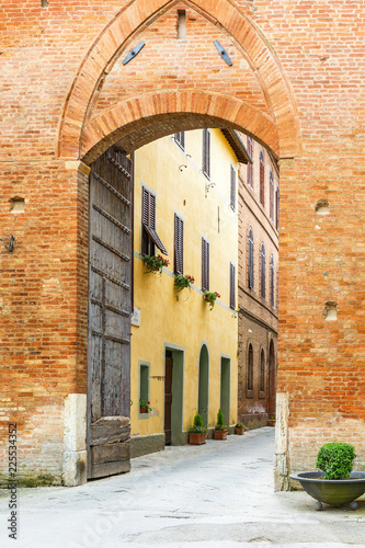Fototapeta Naklejka Na Ścianę i Meble -  Street through a city gate to an old Italian village