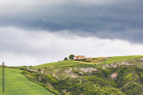 Farm on a hill with dark rain clouds