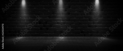 Background of an empty dark-black room. Empty brick walls  lights  smoke  glow  rays