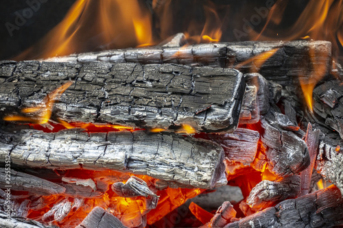 A beautiful red flame on wooden firewood. Dark gray and black coals. Preparation of coals from firewood for cooking barbecue