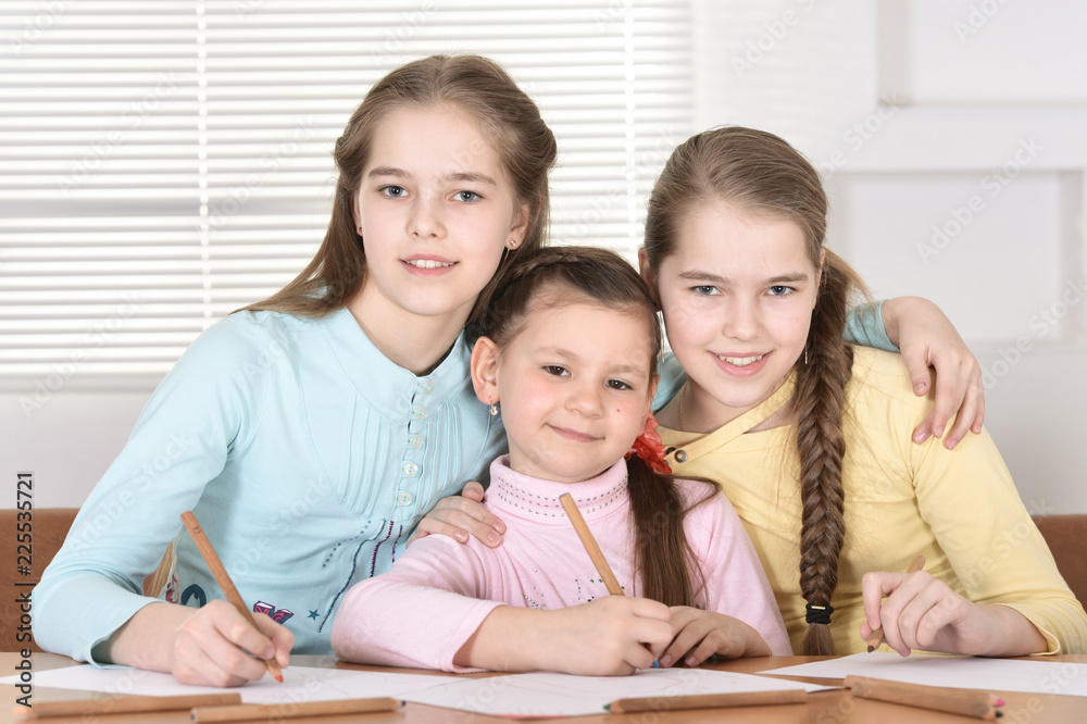 Portrait of beautiful girls doing homework at table Portrait of beautiful girls doing homework at table