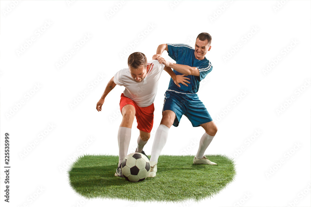 Football players tackling for the ball over white background. Professional football soccer players in motion isolated white studio background. Fit jumping men in action, jump, movement at game. Football players tackling for the ball over white background. Professional football soccer players in motion isolated white studio background. Fit jumping men in action, jump, movement at game.
