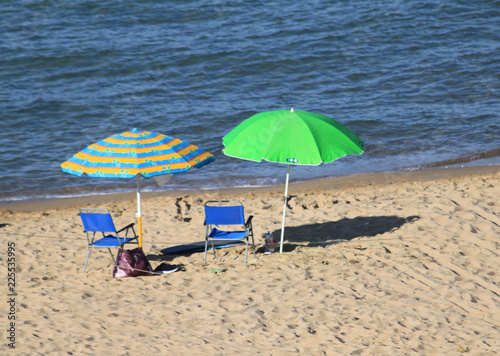 spiaggia deserta con ombrelloni e bagnante