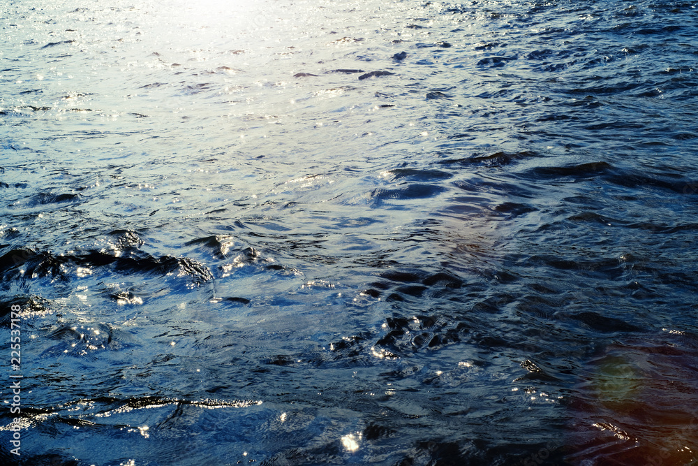 Obraz premium Water surface with ripples and sunlight reflections