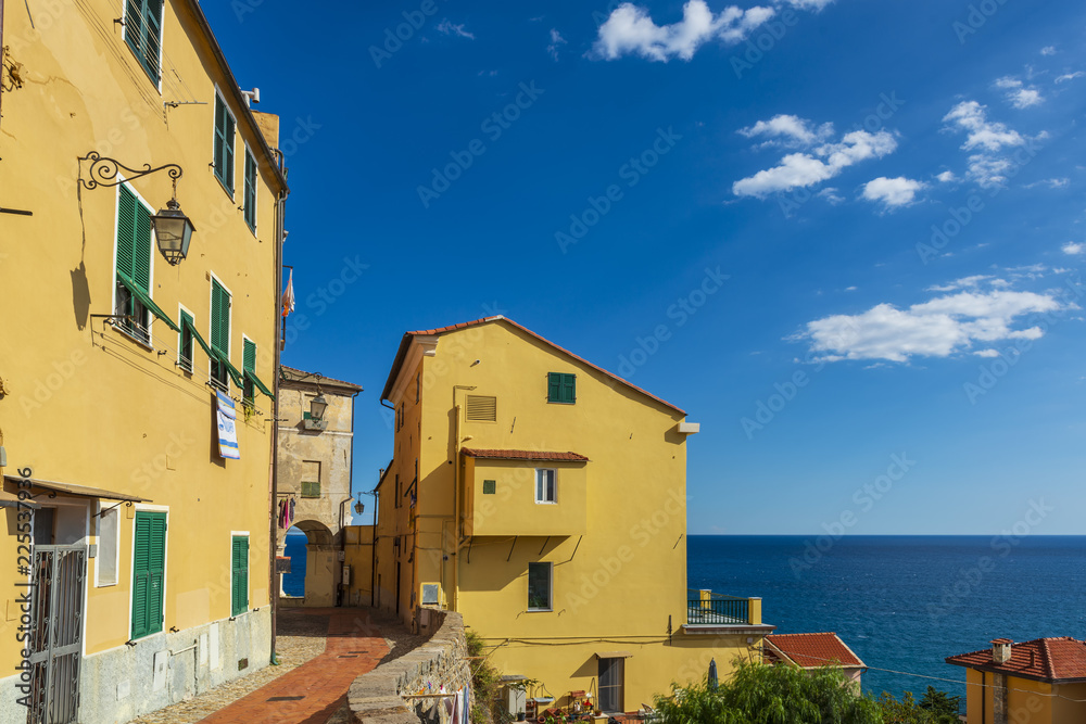 Vibrant streets of mediterranian town with deep blue sky and sea on the background.