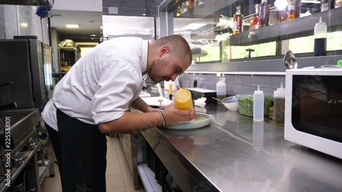 Professional cook in restaurant kitchen preparing a plate for serving to the clients