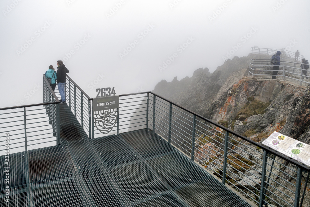 Fototapeta premium Tourists on top of the peak Lomnicky stit, Slovakia