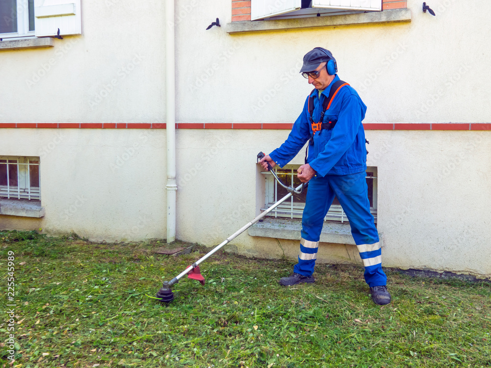 Cutting grass in garden with the trimmer Cutting grass in garden with the trimmer