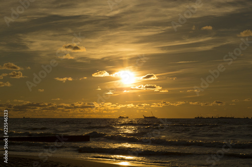 beautiful rays of the sun at sunset and light cirrus clouds on the beach of the Baltic Sea © Alexandra