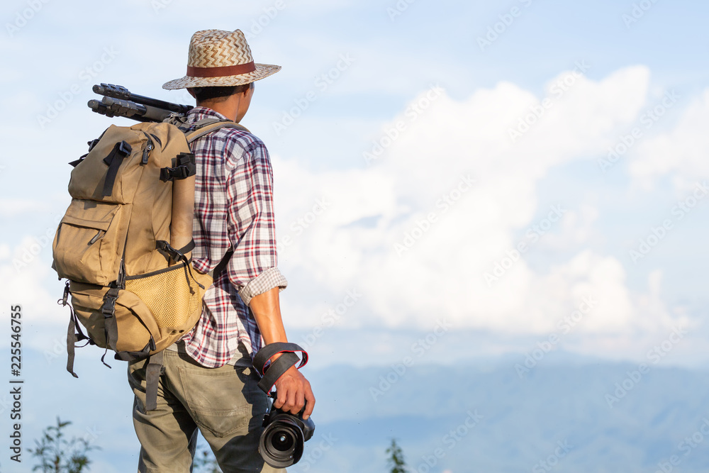 Male hiker with backpack standing on top with beautiful scenery on Asia environment with green vegetation and high mountains Male hiker with backpack standing on top with beautiful scenery on Asia environment with green vegetation and high mountains
