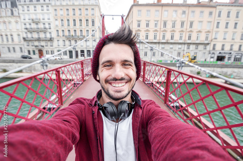 Urban selfie of an handome man smiling at the camera on vacation