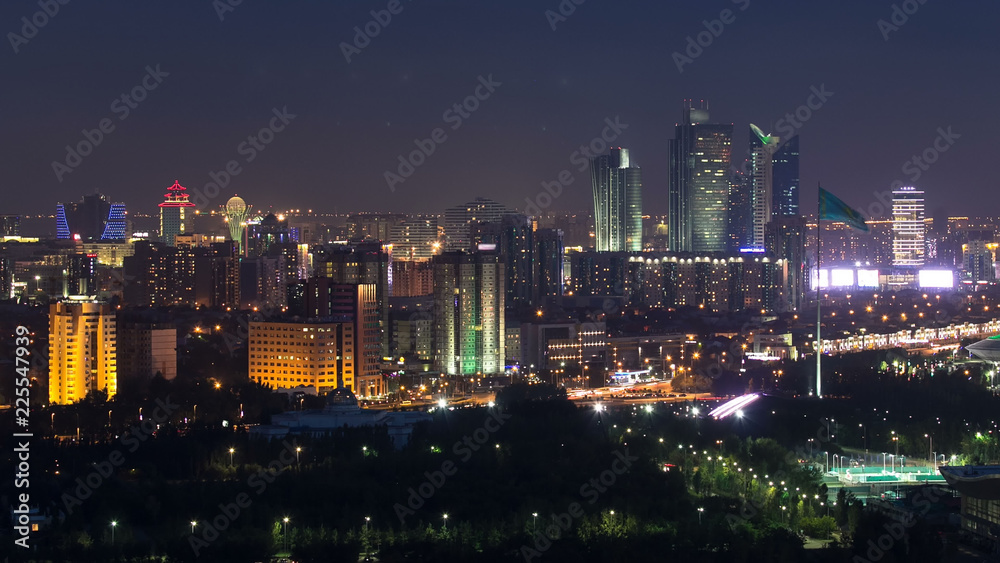 Fototapeta premium Elevated night view over the city center and central business district with bayterek Timelapse, Kazakhstan, Astana