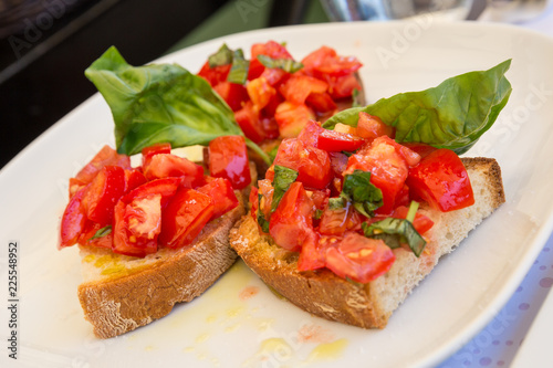 Tomato basil and olive oil bruschetta on a white plate