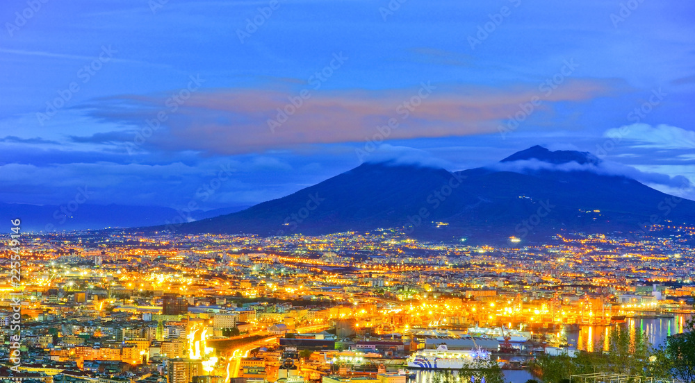View of the city center of Naples and Mount Vesuvius along the Gulf of Naples at night in Naples, Italy.