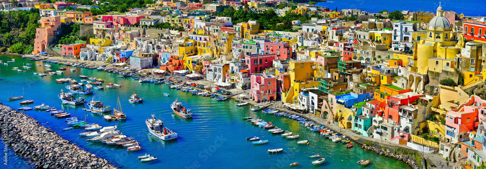 View of the Port of Corricella with lots of colorful houses on a sunny day in Procida Island, Italy.