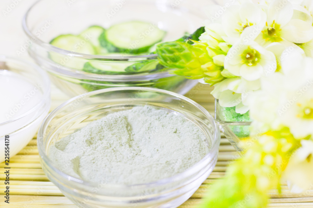 Cucumber home spa and hair care concept. Sliced cucumber, bottles of oil, sea salt, bathroom towel. Straw light background Cucumber home spa and hair care concept. Sliced cucumber, bottles of oil, sea salt, bathroom towel. Straw light background