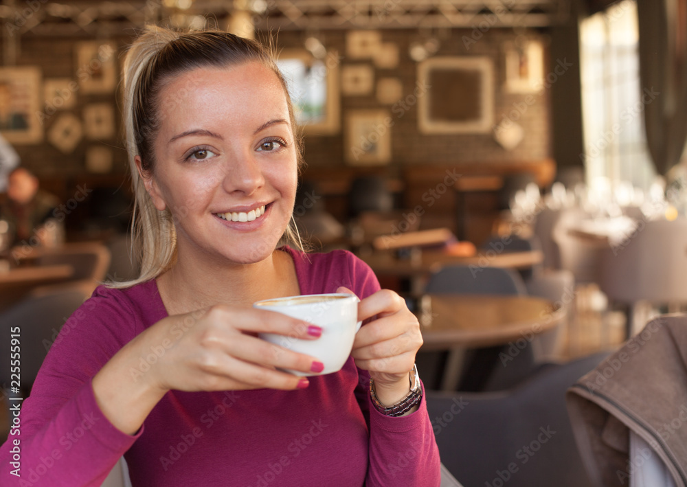 Happy young woman drinking coffee in cafe Happy young woman drinking coffee in cafe