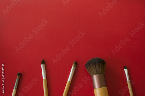 makeup brushes are placed on a red background.