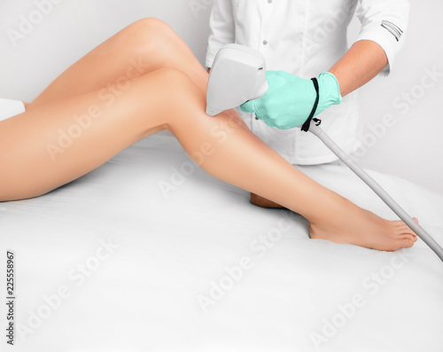 Woman getting laser hair removal in her legs , laser procedure at clinic. Beautiful smooth female legs without hair