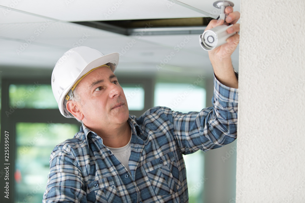 technician worker installing video surveillance camera on wall technician worker installing video surveillance camera on wall