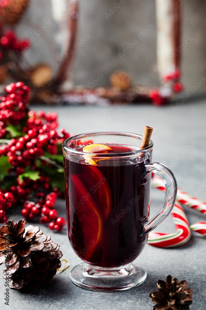 Mulled red wine with spices, orange slices on grey table. New year and Christmas background. Mulled red wine with spices, orange slices on grey table. New year and Christmas background.