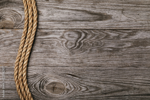 Rope on the background of an old wooden board with copy space, top view
