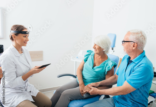 Mature couple  senior patients in ENT clinic talking with doctor