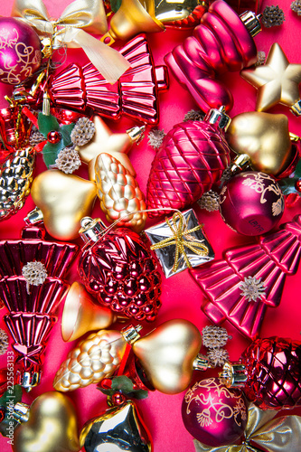 A top view of  mixed golden and red Christmas ornaments on red background