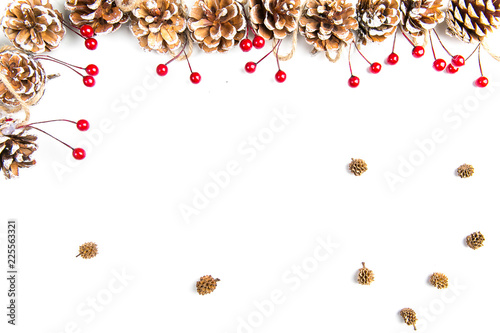 A top view of a christmas ornaments: pine cones awith red berries on white background