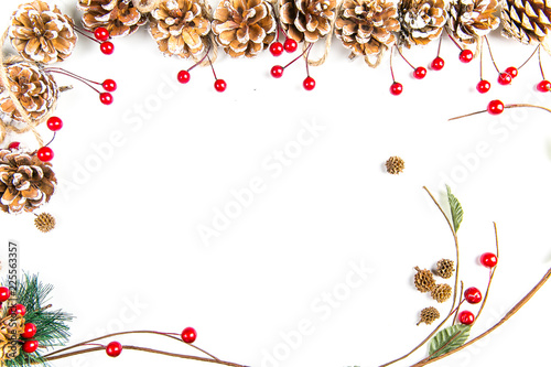 A top view of a christmas ornaments: pine cones awith red berries, curved twigs and pine needles on white background