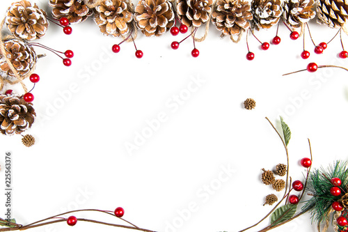 A top view of a christmas ornaments: pine cones awith red berries, curved twigs and pine needles on white background
