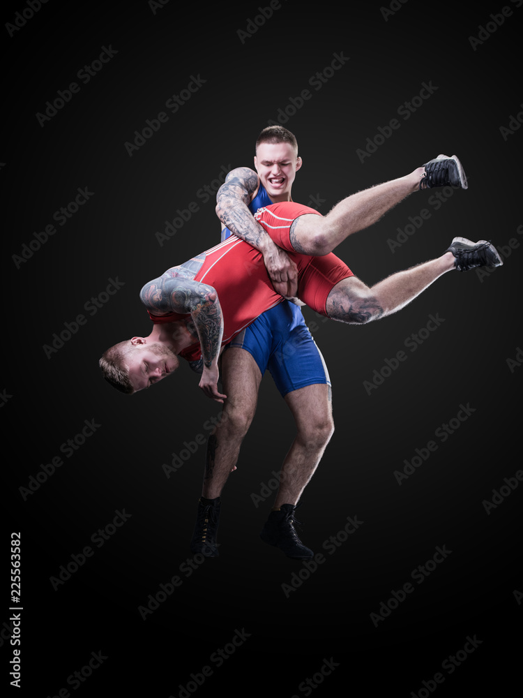 two wrestlers figting isolated on black back