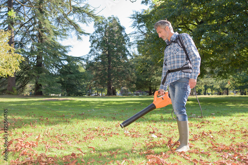 Фотография Man using portable leaf blower