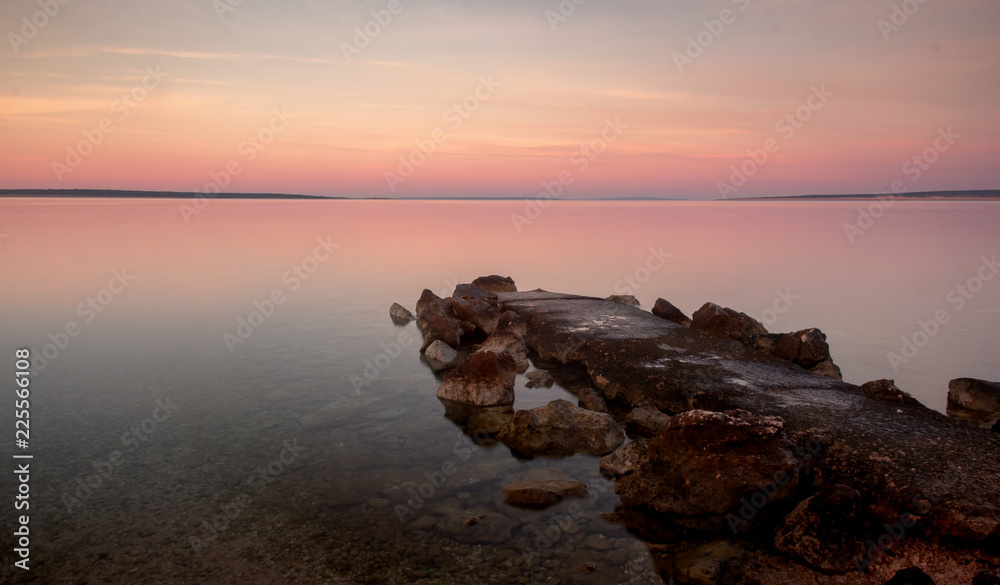 Croatian Sunrise Morning with Rocky Jetty on Beach and Pastel Color Sky