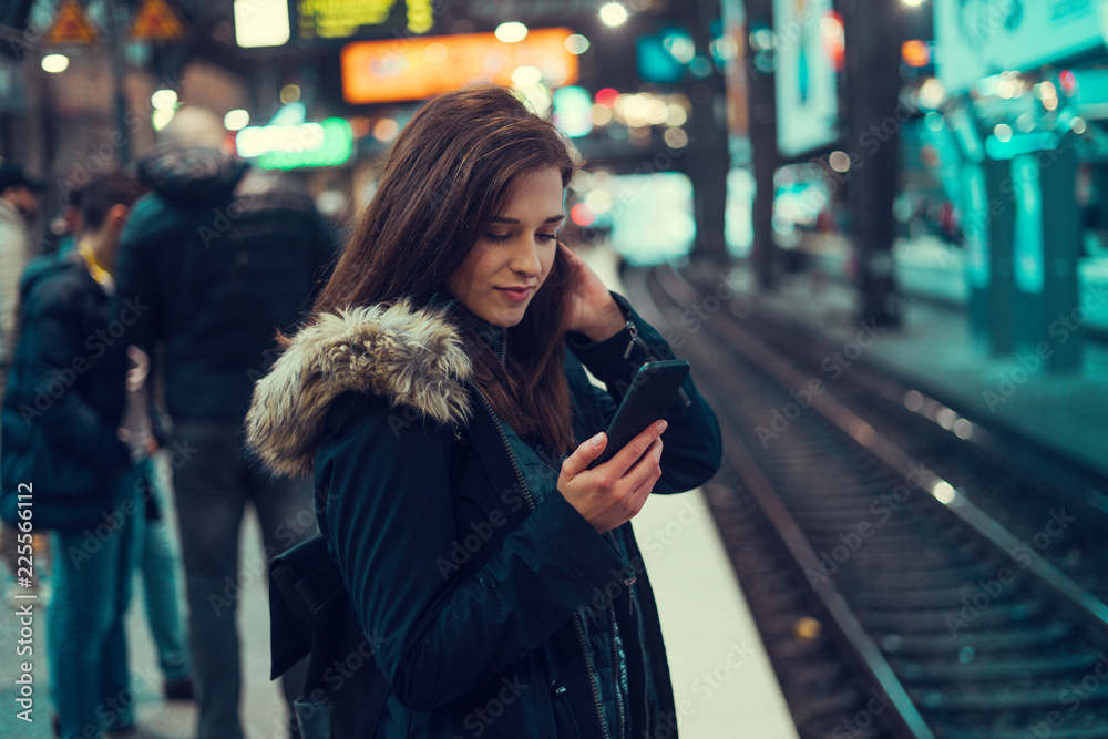 Beautiful young brunette looking at her phone under the bridge Beautiful young brunette looking at her phone under the bridge
