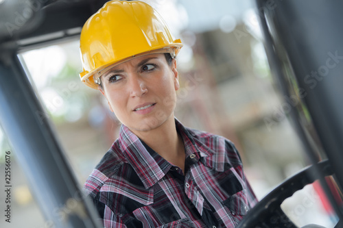 young female construction worker driving heavy equipment