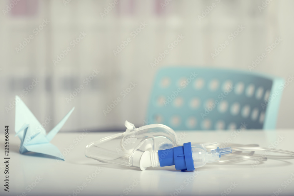 Nebulizer mask on a table and blue crane and blue chair