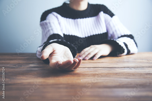 woman showing her palms at a wooden table