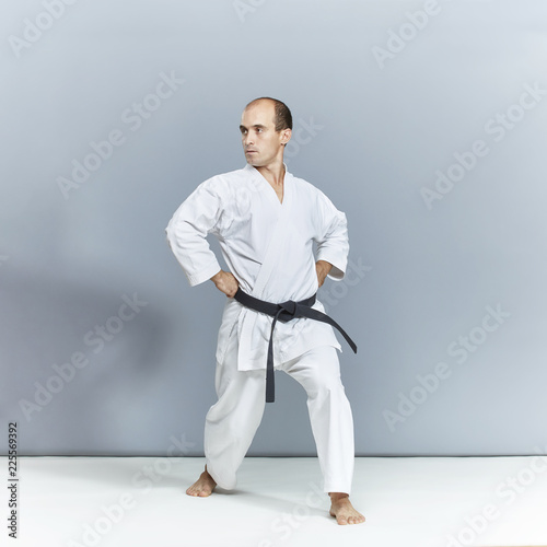 Athlete performs formal karate exercises in white karategi