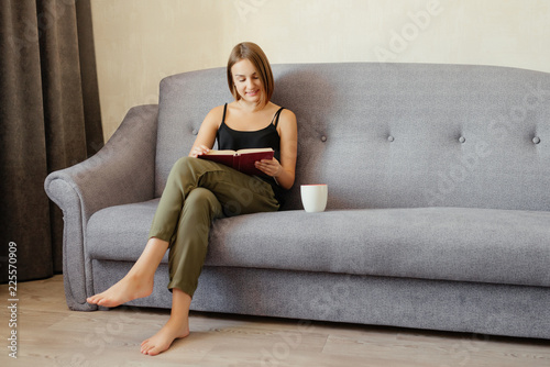 Attractive woman reading a book while drinking a coffee