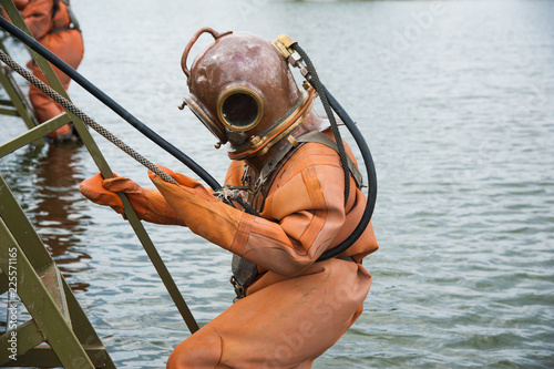 Diver immerses in a vintage deep sea diving suit