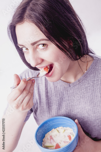 Healthy food. Portrait of young woman having breakfast and eating muslin.