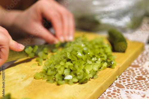 cook cuts a green salad on a cutting Board