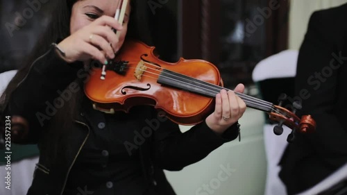 Musician playing violin outdoors. 
Violint play music for the wedding. Violin under the open sky. Wedding music concept.