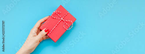 Woman hand holding red present gift box