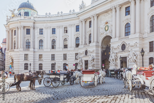Horse drawn carriages hackney coaches standing in front of Hofburg, Imperial Palace in Vienna