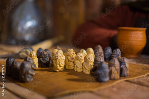 Close up shot - two men in russian ethnic suit playing medieval popular strategy board game - tafl. Folk, competition and traditional concept photo